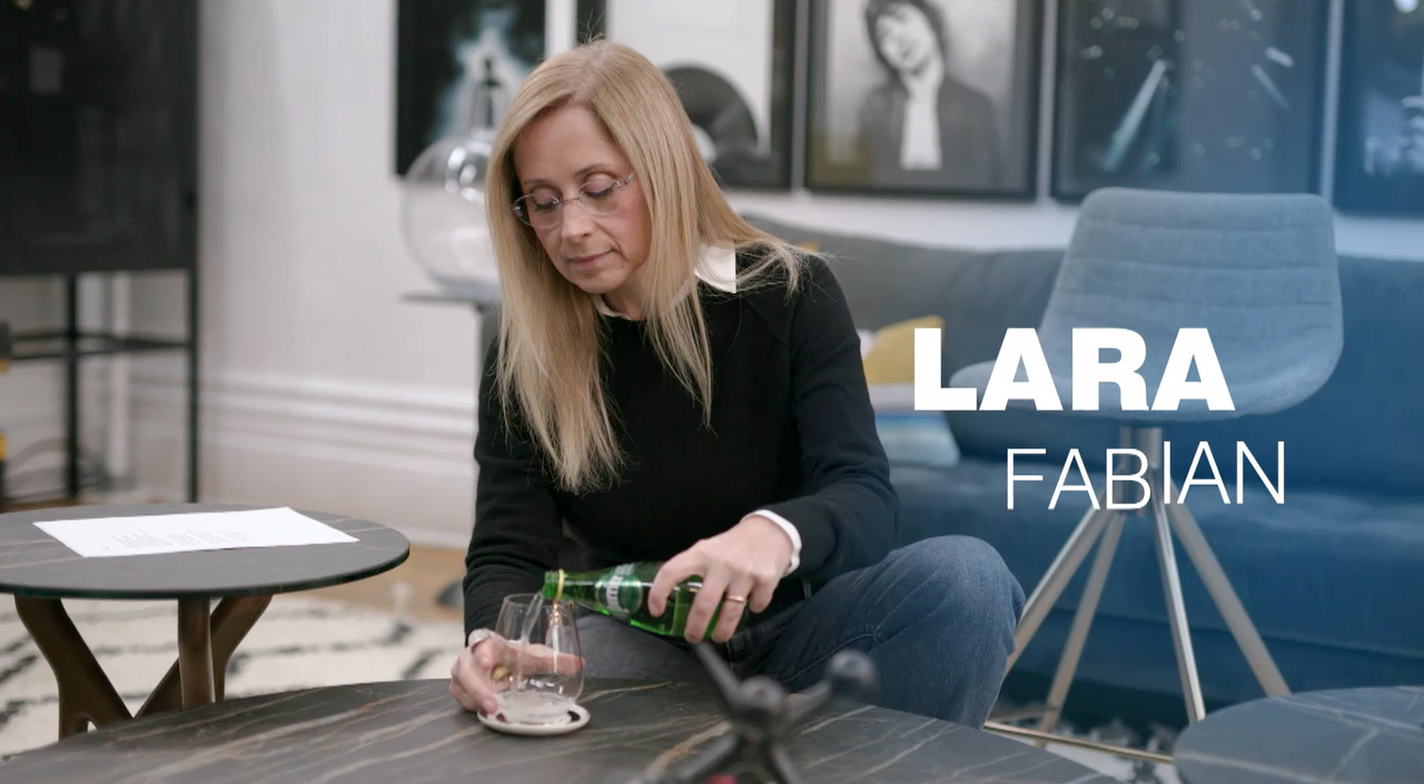 Lara Fabian se verse un verre de Perrier durant une émission de Star académie.