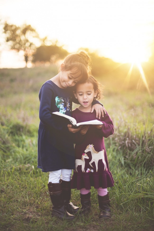 Deux jeunes filles lisent un livre à l'extérieur