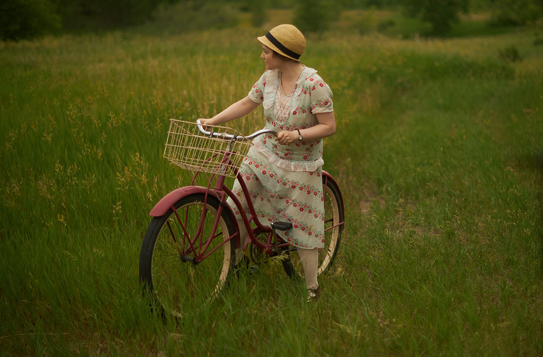 Romane Denis joue Gabrielle Roy, elle fait du vélo dans un champ.